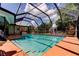 A screened-in pool area featuring a refreshing pool and an inviting hanging chair for ultimate relaxation and enjoyment at 604 Knollwood Dr, Largo, FL 33770