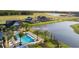 Aerial view of a community pool and pond with beautiful homes and landscaping at 6057 Marsh Trail Dr, Odessa, FL 33556