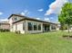 Expansive backyard featuring lush green lawn and covered patio, perfect for outdoor living at 6057 Marsh Trail Dr, Odessa, FL 33556