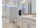 Bright bathroom featuring double sinks with modern fixtures and a shower with a patterned curtain at 6057 Marsh Trail Dr, Odessa, FL 33556