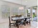 Light and airy dining room with a dark wood table and view to outdoor patio area at 6057 Marsh Trail Dr, Odessa, FL 33556