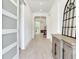 Bright and airy entryway featuring white walls, decorative mirror, and wood flooring at 6057 Marsh Trail Dr, Odessa, FL 33556