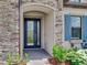 A stunning front door featuring glass panes and stone surround, enhanced by lush landscaping at 6057 Marsh Trail Dr, Odessa, FL 33556