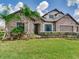 Beautiful home featuring stone accents, lush landscaping and a well-manicured lawn at 6057 Marsh Trail Dr, Odessa, FL 33556