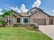 Beautiful stone home with a well-manicured lawn, palm tree and paved driveway on a sunny day at 6057 Marsh Trail Dr, Odessa, FL 33556