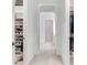 Bright hallway connecting closets, bathroom and bedroom featuring white and arched doorways at 6057 Marsh Trail Dr, Odessa, FL 33556