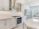 A white kitchen, featuring stainless appliances, a gas cooktop, stylish cabinetry, and plenty of counter space at 6057 Marsh Trail Dr, Odessa, FL 33556