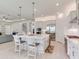 An open concept kitchen with an island, bar seating, stainless steel appliances, and access to the living and dining areas at 6057 Marsh Trail Dr, Odessa, FL 33556