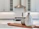 A close up of a kitchen island with white subway tile backsplash and decorative vases on a cutting board at 6057 Marsh Trail Dr, Odessa, FL 33556