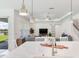 A close-up of a kitchen island featuring a sink, seating, and views of the living area at 6057 Marsh Trail Dr, Odessa, FL 33556