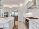 Bright kitchen with stainless steel appliances, white cabinets, farmhouse sink, and a large island at 6057 Marsh Trail Dr, Odessa, FL 33556
