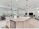 Open kitchen featuring a large island with seating, stainless steel appliances, and seamless flow into the dining and living areas at 6057 Marsh Trail Dr, Odessa, FL 33556
