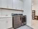 Convenient laundry room with modern washer/dryer, sink, and ample cabinet space at 6057 Marsh Trail Dr, Odessa, FL 33556