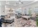 Bright, open-concept living space with a large sectional sofa, a colorful rug, and seamless access to the modern kitchen at 6057 Marsh Trail Dr, Odessa, FL 33556