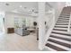 Spacious living room featuring a light sofa, neutral walls, and staircase with dark wood treads at 6057 Marsh Trail Dr, Odessa, FL 33556