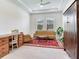Comfortable living room with vintage furnishings, a red rug, and ample natural light from large windows at 6057 Marsh Trail Dr, Odessa, FL 33556