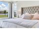 Close-up of a luxurious main bedroom with a lake view and plush bedding at 6057 Marsh Trail Dr, Odessa, FL 33556