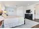 Bright main bedroom with hardwood floors, a bedside table, and a TV at 6057 Marsh Trail Dr, Odessa, FL 33556