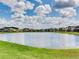 Community pond surrounded by green grass offers a serene and picturesque view for residents at 6057 Marsh Trail Dr, Odessa, FL 33556