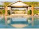 Community pool with covered outdoor seating, palm trees, and beautiful landscaping at 6057 Marsh Trail Dr, Odessa, FL 33556