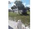 This backyard features a grassy lawn, two large palm trees, and decorative landscaping at 702 Cypress Pl, Sun City Center, FL 33573