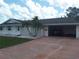 Charming single-story home featuring mature palms, an attached garage, and a well-maintained front yard at 702 Cypress Pl, Sun City Center, FL 33573