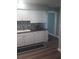 Modern kitchen with white cabinets, dark countertops, and stainless steel sink with stylish backsplash at 702 Cypress Pl, Sun City Center, FL 33573