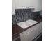 Updated kitchen features a stainless steel faucet, white cabinetry, and mosaic backsplash at 702 Cypress Pl, Sun City Center, FL 33573
