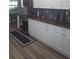 Updated kitchen features white cabinets, stylish backsplash, and stainless steel appliances at 702 Cypress Pl, Sun City Center, FL 33573