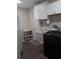 Laundry room with black washer and dryer, stainless sink, vanity mirror, and hanging cabinets at 702 Cypress Pl, Sun City Center, FL 33573