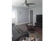 Bright living room features dark wood floors, a ceiling fan, and coastal decor at 702 Cypress Pl, Sun City Center, FL 33573
