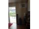 Well-lit utility room with a small window air conditioner, storage shelf, and an exterior door at 702 Cypress Pl, Sun City Center, FL 33573