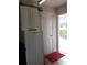 Utility room with cabinets, white door to exterior, and a small red rug on the floor at 702 Cypress Pl, Sun City Center, FL 33573