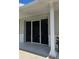 Covered back porch showing sliding glass doors, with a brick column, and gray painted trim at 7427 Banner St, New Port Richey, FL 34653
