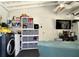 Finished basement with laundry area, storage shelving, and entertainment setup, perfect for a multi-functional living space at 7427 Banner St, New Port Richey, FL 34653