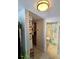 Hallway view leading to a well-lit bathroom, showcasing tiled floors and a stylish shower curtain at 7427 Banner St, New Port Richey, FL 34653