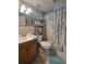 Functional bathroom with a sink vanity, toilet, shower and useful storage shelves at 7427 Banner St, New Port Richey, FL 34653