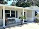 A charming home entrance with potted plants, brickwork and outdoor seating at 7427 Banner St, New Port Richey, FL 34653