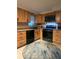 Efficient kitchen featuring warm wood cabinetry, black appliances, and a window over the sink at 7427 Banner St, New Port Richey, FL 34653