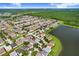Expansive aerial view of a residential community next to a lake with green space and beautiful blue skies above at 7515 Dragon Fly Loop, Gibsonton, FL 33534