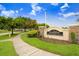 South Bay Lakes community entrance sign with stone accents, lush landscaping, and a sidewalk along a tree-lined street at 7515 Dragon Fly Loop, Gibsonton, FL 33534