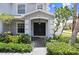Inviting covered front porch with a stylish front door, tiled flooring, and beautifully manicured landscaping at 7515 Dragon Fly Loop, Gibsonton, FL 33534