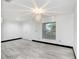 Inviting living room with new gray toned flooring, neutral walls, modern light fixture and lots of natural light at 7515 Dragon Fly Loop, Gibsonton, FL 33534