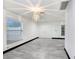Bright living room featuring sleek flooring, fresh paint, and a modern light fixture, leading into the kitchen area at 7515 Dragon Fly Loop, Gibsonton, FL 33534