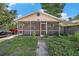 Charming single-story home featuring a screened porch, brick facade, and lovely landscaping at 8606 N 9Th St, Tampa, FL 33604