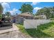 The property has a brick facade, a screened-in front porch and a partial white picket fence at 8606 N 9Th St, Tampa, FL 33604
