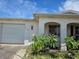 Charming home featuring a one-car garage, front yard landscaping, and an arched entryway with a security screen at 9505 Marlinton Ln, Port Richey, FL 34668