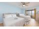 Bright bedroom with two beds and access to a balcony, offering a comfortable and airy space at 11000 Gulf Blvd # 1004, Treasure Island, FL 33706