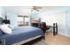 Bright bedroom with a ceiling fan, desk, and sliding glass doors to a private balcony with an ocean view at 11000 Gulf Blvd # 1004, Treasure Island, FL 33706