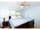 Inviting bedroom with a comfortable bed, a ceiling fan, and a window allowing ample natural light at 11000 Gulf Blvd # 1004, Treasure Island, FL 33706